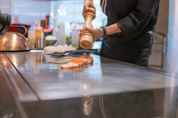 Fototapeta na wymiar Hand of Chef cooking salmon steak