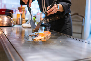 Hand of Chef cooking salmon steak