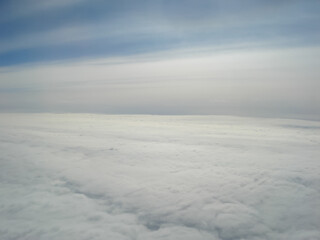 Clouds view from the airplane window. The sky is with cumulus clouds. Beautiful background. Travels. Flying over the cloud. To fly