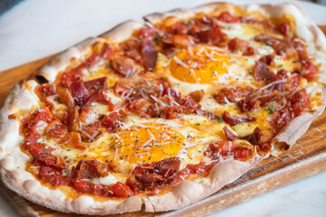Ham and Eggs Breakfast style pizza on wooden platter