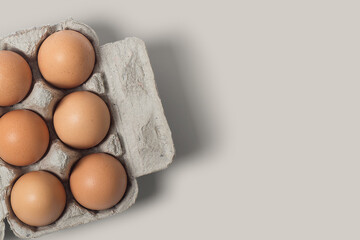 photo or picture of 6 eggs in a box, eggs in a photo with a brown background