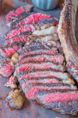 Dry-aged marble beef steak Tomahawk on wooden board with spices. Close-up, dinner concept.