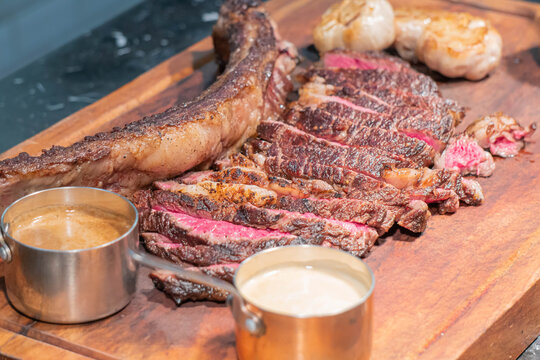 Dry-aged marble beef steak Tomahawk on wooden board with spices. Close-up, dinner concept.