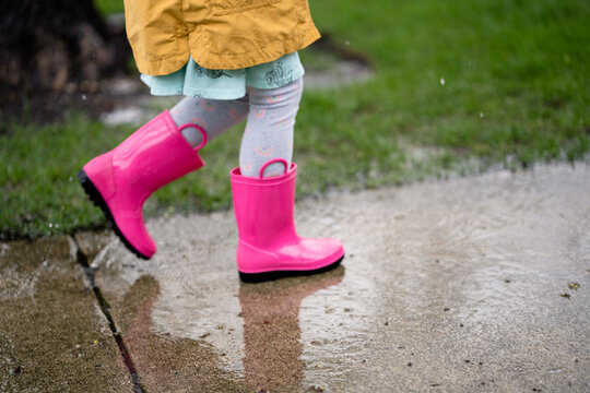 side view of bottom half of girl walking in rain in rainbows
