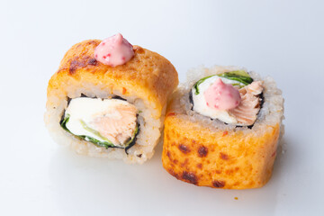traditional Japanese cuisine. japanese sushi isolated on white background. maki sushi with salmon, cucumber, soft cheese (Philadelphia). baked sushi. hot sushi