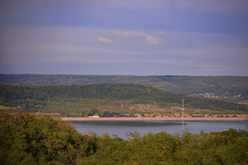 spring landscape with forest near the lake at sunset. cultivated fields