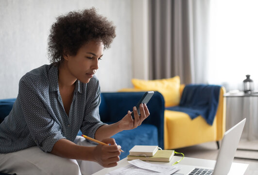 Ethnic woman checking financial data on smartphone
