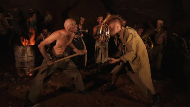 Crazy orchestra playing. Funny musicians play underground in a cave at night. Crazy people play musical instruments and dance funny dances in the cave. Funny bass guitarist, tubist, trumpeter, drummer