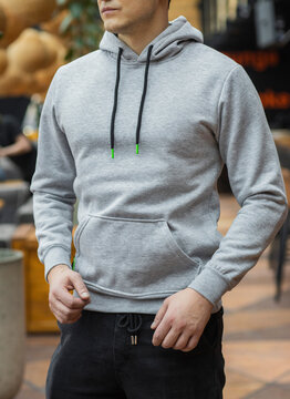 Handsome attractive European muscular man in gray hoodie