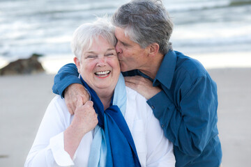Senior husband kissing wife at Cold Storage Beach on Cape Cod
