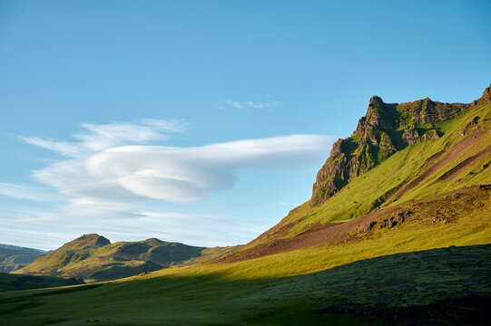 Green slope of high mountain in sunlight