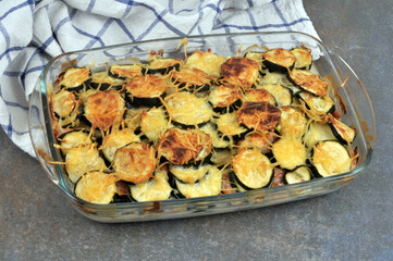 Plat de gratin de courgettes en gros plan à côté d'un torchon