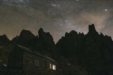Galayos refuge against granite spikes and Milky Way during a winter night, Gredos, Spain