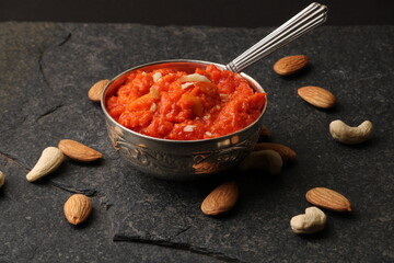 Gajar halwa is a carrot-based sweet dessert pudding from India. Garnished with Cashew almond nuts and Served in silver bowl