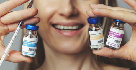 smiling woman with cosmetic injection vials and syringe in hands. anti-aging non surgical treatments
