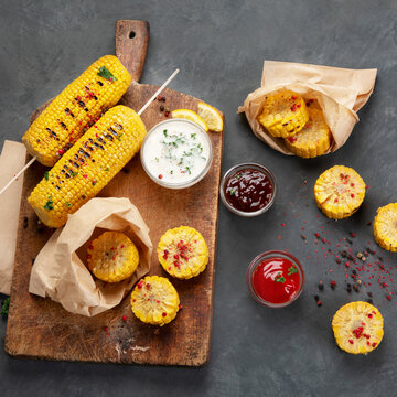 Grilled roasted sweet corn cobs with souces