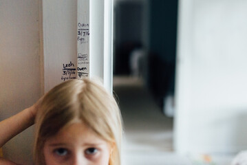 Measuring girl's height at home on door frame