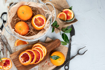 Oranges and juice in basket on light background