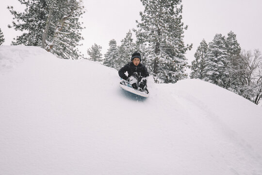 Boy Starts Down Snowy Hill on a Sled.