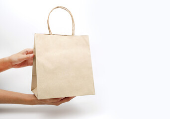 A woman holding a recycled paper bag on a white background.