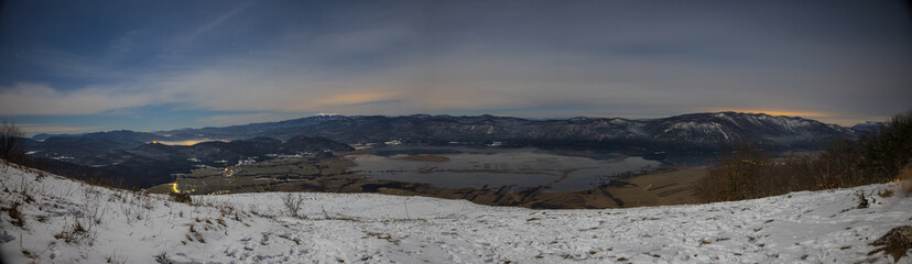 Night panorama of Cerknica lake viewed from above from Slivnica vantage point during late night. Long exposure photo of Cerknica lake.
