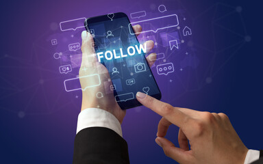 Female hand typing on smartphone with FOLLOW inscription, social media concept