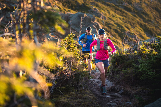 Man and woman trail running at sunrise in the mountains