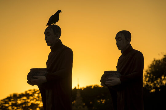 Silhouettes of monk statues at Myo Yar Pyae Pagoda at sunset, Mo