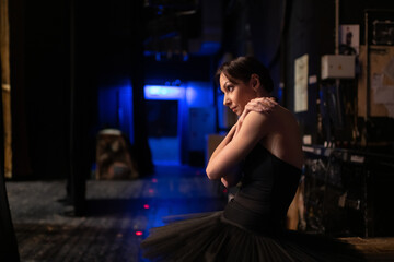 Anxious ballet dancer stretching shoulders
