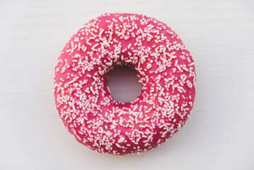 Pink glazed donut on a white background, top view, flat lay.