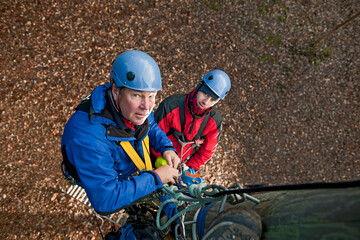 two men working on wooden pole at high rope training exercise