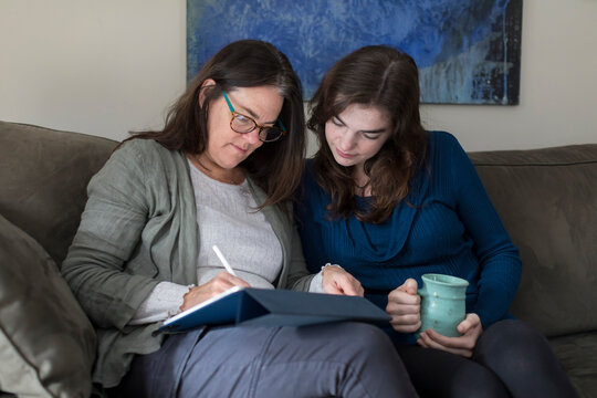 A mother and daughter work on a tablet together