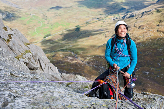 female rock climber at belay anchor point on Tryfan in North Wales