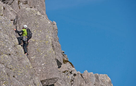 man climbing up rock face on Tryfan in North Wales