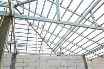 Aerated brick wall and steel roof frame in the construction site,Construction concept.