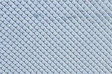 Mesh fence covered with white frost, Chain link fence and snow. Winter landscape.