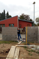 Master on the construction site, construction of a fence on a private territory, concrete type fence.