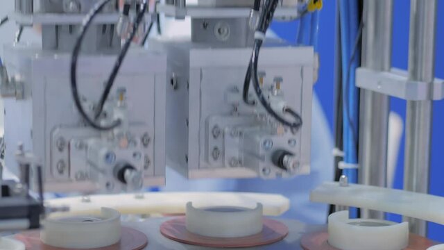 Automatic vacuum capping machine during work in demonstration mode at packaging exhibition, trade show - close up view. Manufacturing, industry, automated technology equipment concept