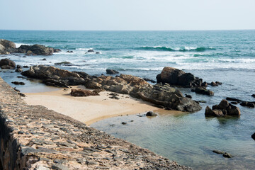 Fototapeta na wymiar Coastal landscape with rocks, beach and calm sea at Galle, Sri Lanka on a sunny day