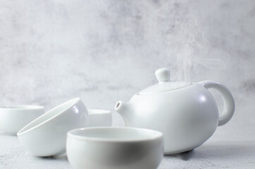 Tea time pot and white tea cup family on smoke background feel aromatic of hot drinks, Japanese and Chinese green refreshment. Theme of Family mother and children. Food and beverage concept
