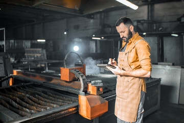 Heavy industry worker controlling the process of metal cutting