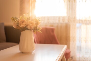 Pot of rose flowers isolated on table with sunshine light.