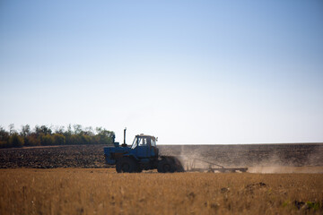 Fototapeta premium Tractor plowing fields -preparing land for sowing