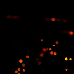 Orange bokeh on a black background, burning and blurred sparks from the fire. Particles of burning embers fly and glow isolated in the night sky.