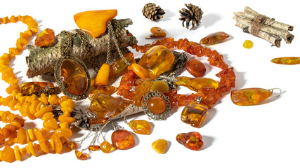 Different dazzling old Baltic amber jewelry is beautifully laid out on a birch bark on a white...