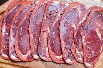 beef bacon sliced on wood board. blurry background. traditional turkish food pastirma