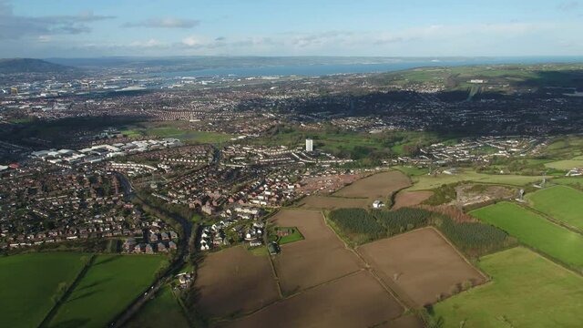Aerial flyover of east Belfast from the countryside looking towards the city centre or center
