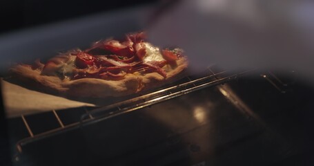 Homemade pizza being checked on in oven