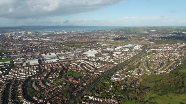 Aerial flyover of east Belfast from the countryside looking towards the city centre or center