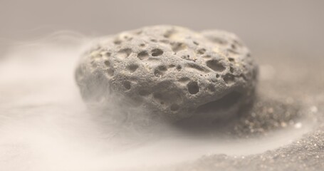 Fototapeta na wymiar Smoke whirling around small meteorite stone